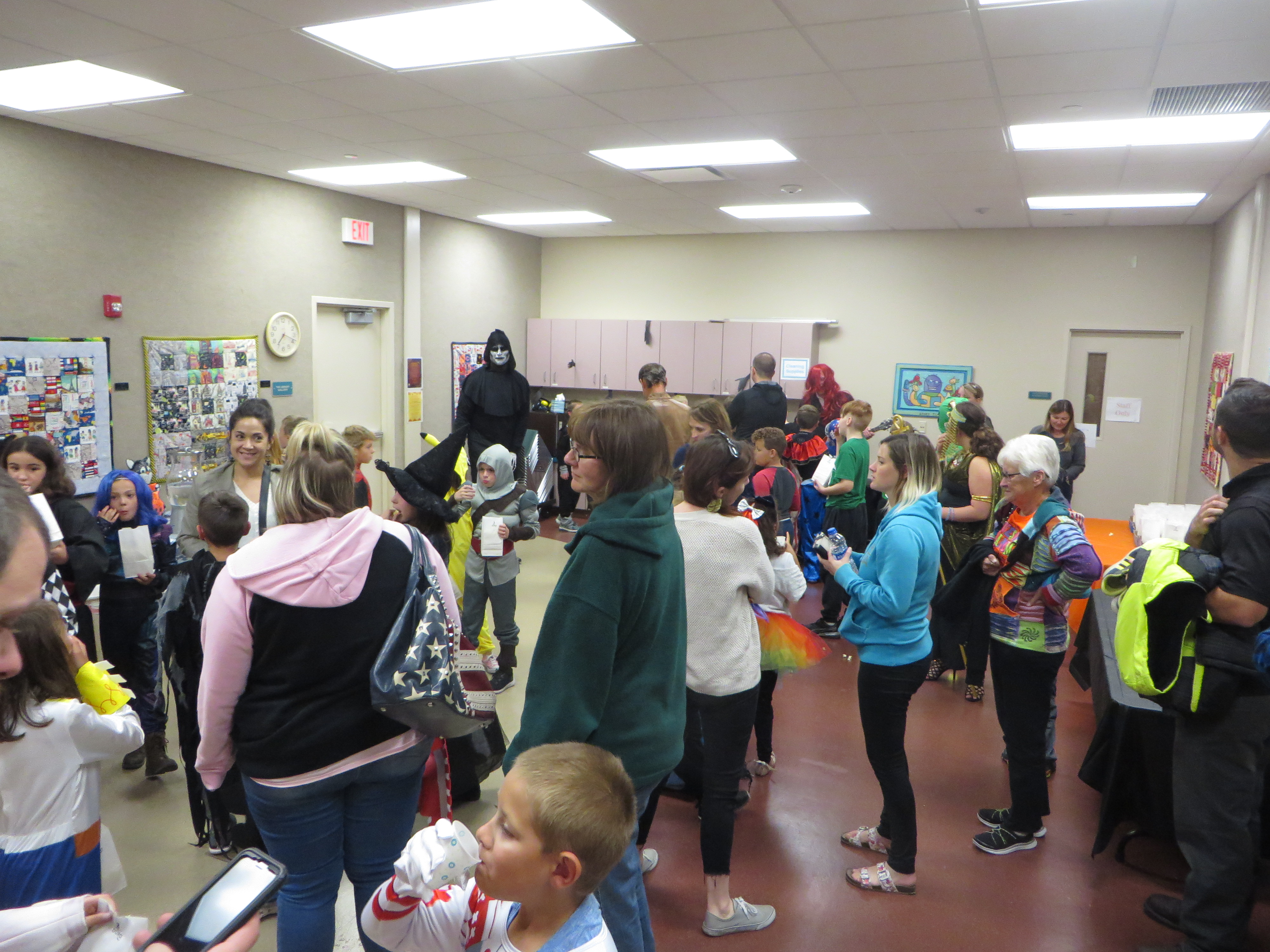 A group of children in costumes and adults mingles.