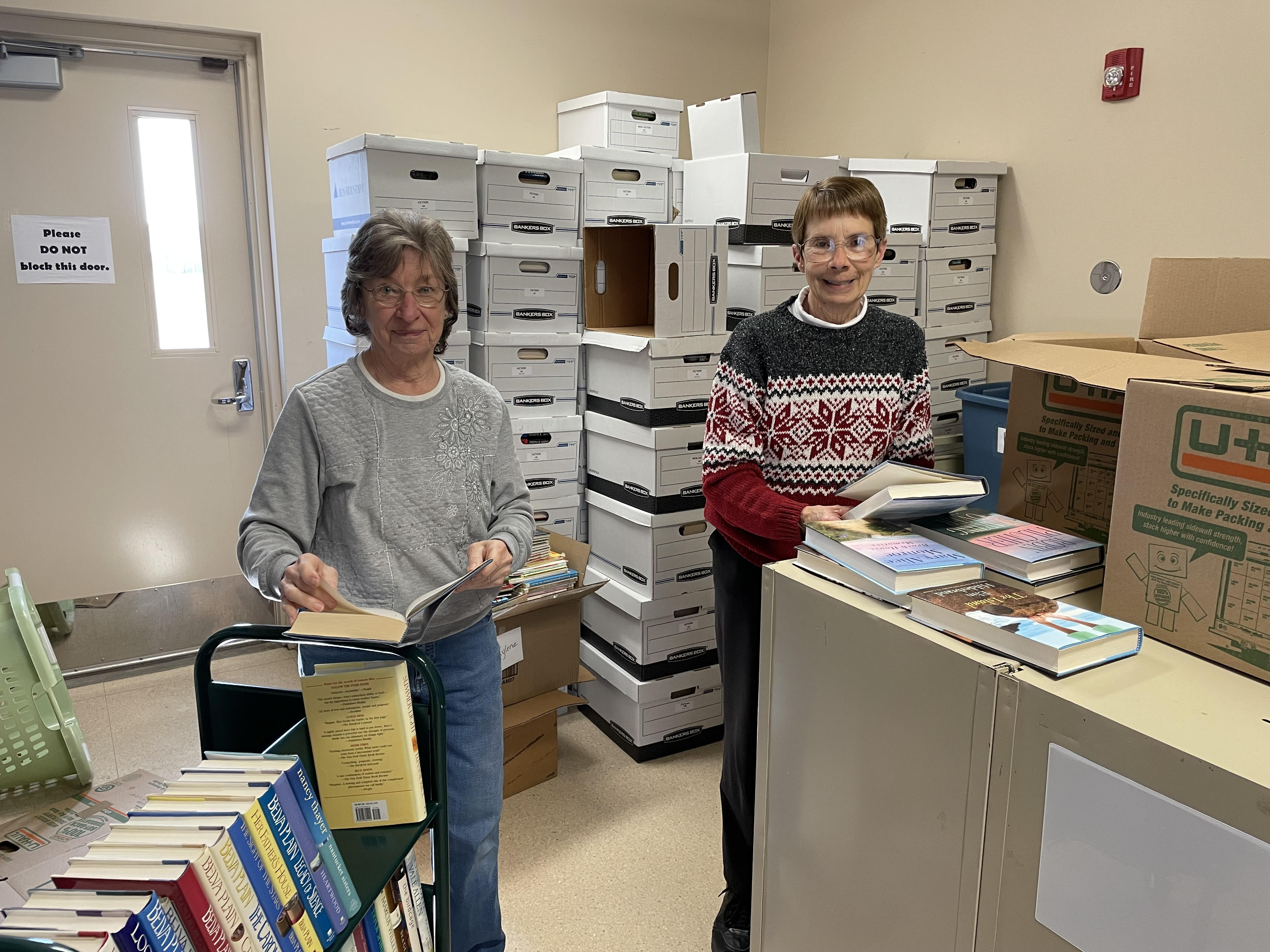 Volunteers Twila and Kylene sorting out donated books for the book sale!