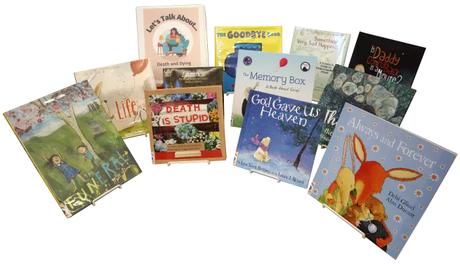 Eleven children&#039;s picture books and a binder propped on easels. The binder is labeled &quot;Let&#039;s Talk About... Death and Dying&quot;