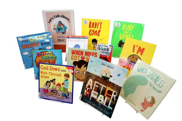 Ten children&#039;s picture books and a binder propped on easels. The binder is labeled &quot;Let&#039;s Talk About... Dementia&quot;