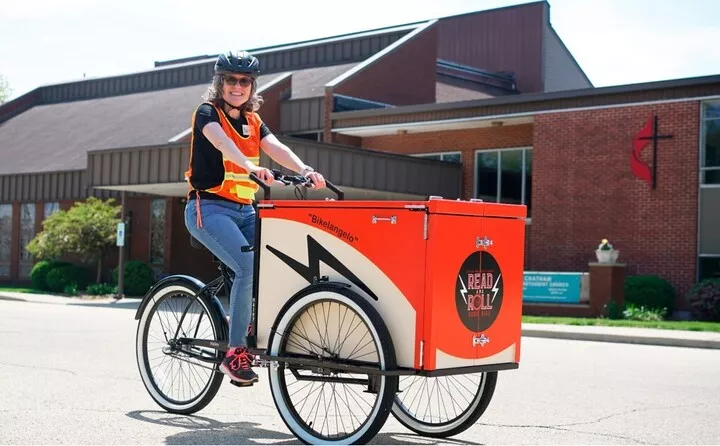 staff member riding the book bike