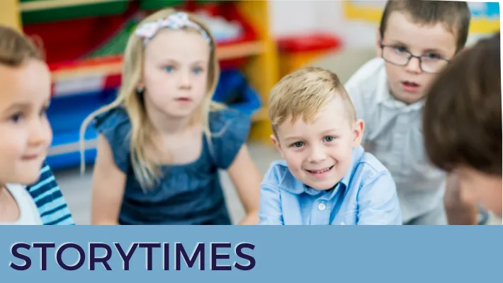 children sitting on the ground listening to librarian read book