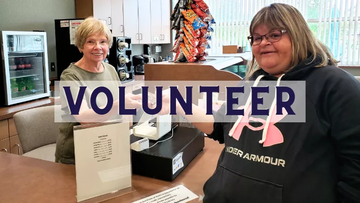 Friends&#039; bookstore and cafe volunteer helping patron with a purchase